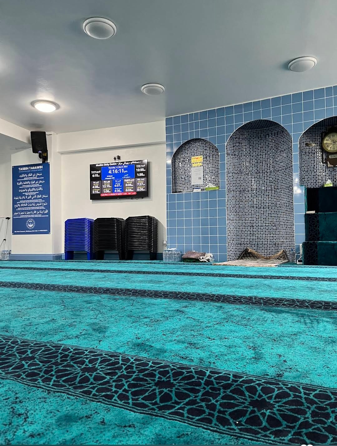 Spacious prayer hall with traditional teal carpet